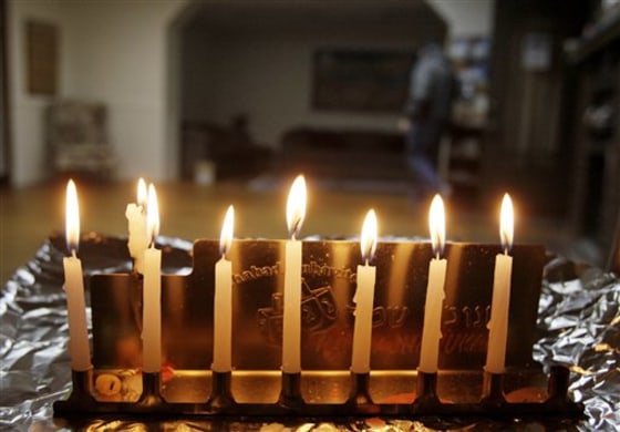 Alex Groysman, president of Chabad House in Bloomington, Ind., walks in the background as a menorah is lit.